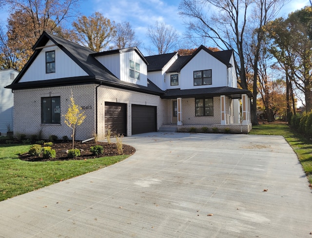 modern inspired farmhouse with a porch, a garage, and a front lawn