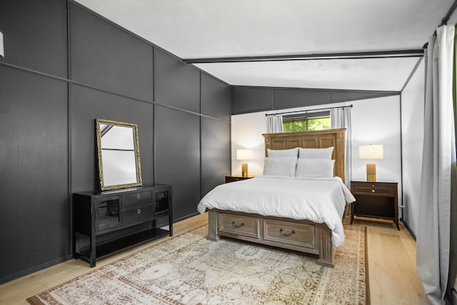 bedroom featuring light hardwood / wood-style floors and vaulted ceiling