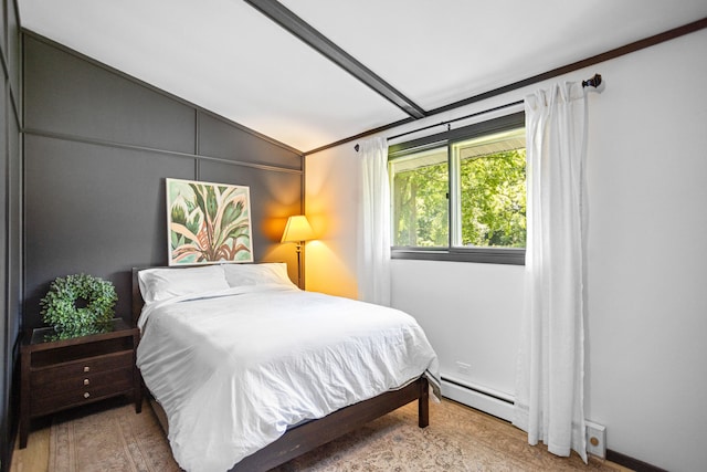 bedroom featuring baseboard heating, light hardwood / wood-style flooring, and lofted ceiling