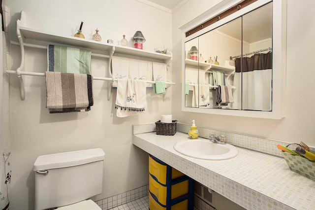 bathroom featuring toilet, sink, and ornamental molding