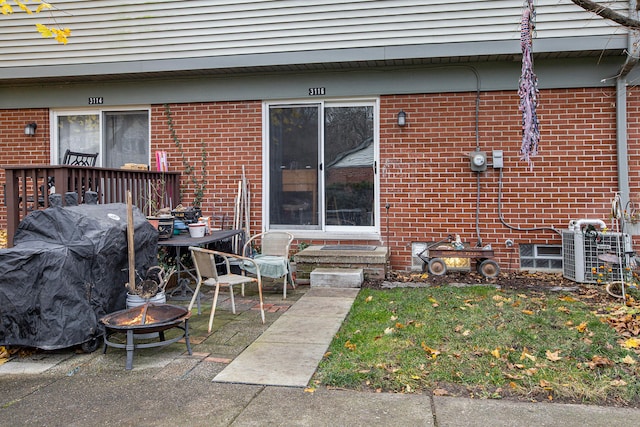 rear view of property with an outdoor fire pit and cooling unit