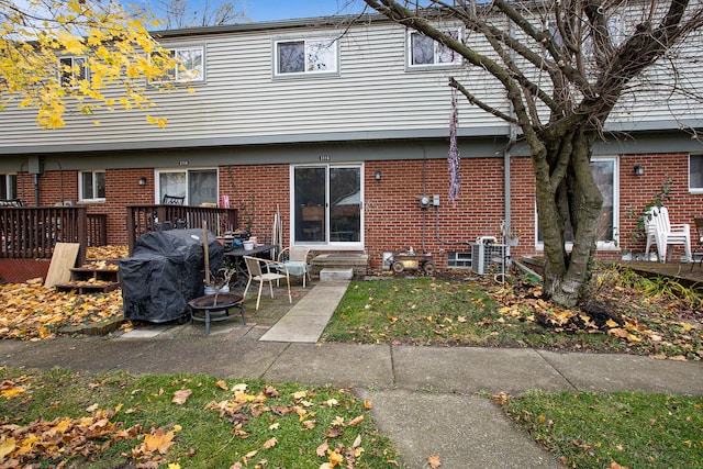 rear view of property with a fire pit and a deck