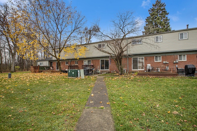 back of house featuring a yard and a wooden deck