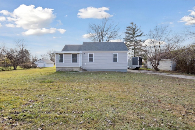 back of property with a yard and a storage shed