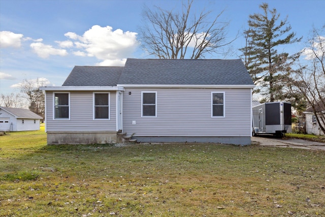 rear view of property with a storage unit and a yard