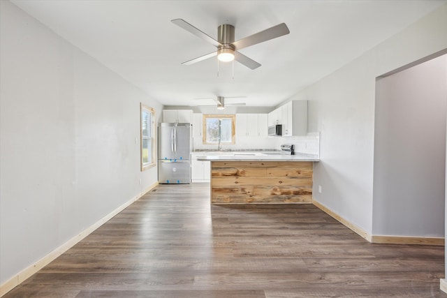 kitchen featuring white cabinets, ceiling fan, decorative backsplash, dark hardwood / wood-style flooring, and stainless steel appliances