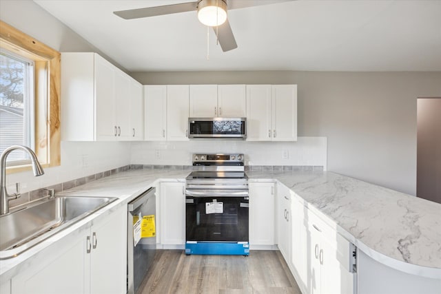 kitchen with white cabinetry, light hardwood / wood-style flooring, sink, and appliances with stainless steel finishes