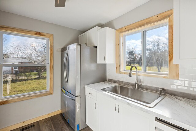 kitchen with dark wood-type flooring, sink, appliances with stainless steel finishes, tasteful backsplash, and white cabinetry