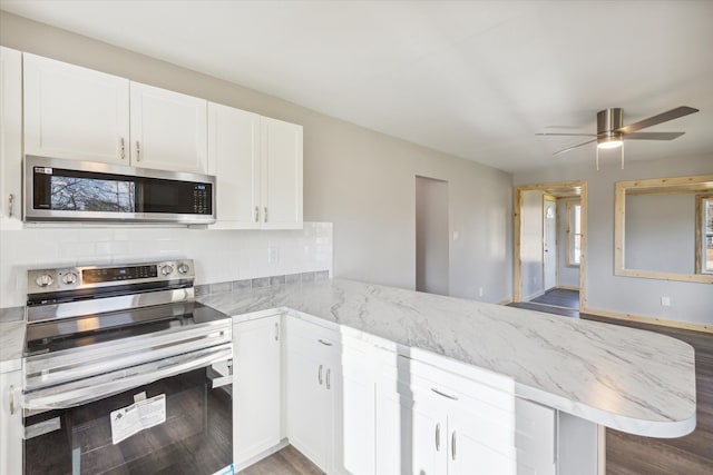 kitchen with kitchen peninsula, appliances with stainless steel finishes, white cabinetry, and wood-type flooring