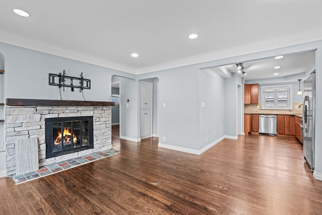 unfurnished living room with a fireplace and dark hardwood / wood-style flooring