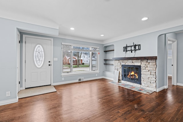 unfurnished living room with a stone fireplace and hardwood / wood-style flooring