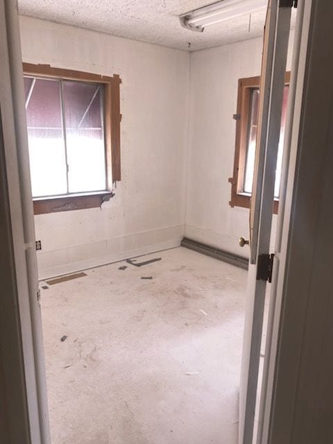 unfurnished room with a textured ceiling