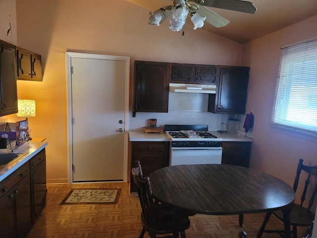 kitchen with light parquet flooring, dark brown cabinetry, white range with gas stovetop, and vaulted ceiling