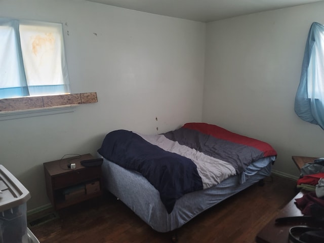 bedroom with dark hardwood / wood-style floors