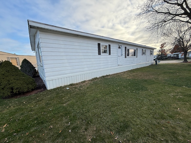 property exterior at dusk with a yard