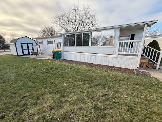 rear view of house with a lawn, a patio area, and a storage shed