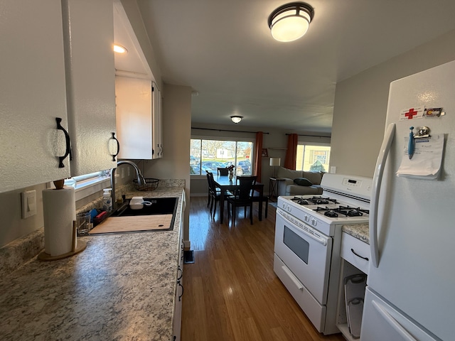 kitchen with white cabinetry, white appliances, sink, and dark wood-type flooring