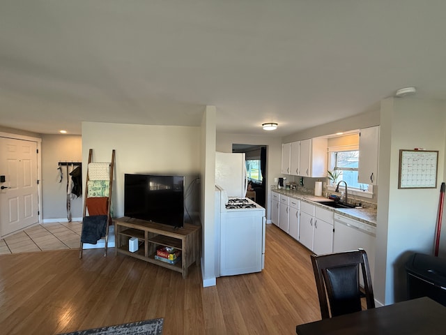 5052 Kenway Ct S, Sterling Heights, MI 48310 - kitchen with light countertops, white cabinets, light wood-type flooring, and a sink