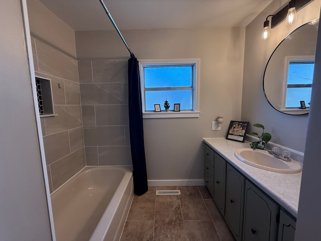 bathroom with shower / bath combo, vanity, and a healthy amount of sunlight