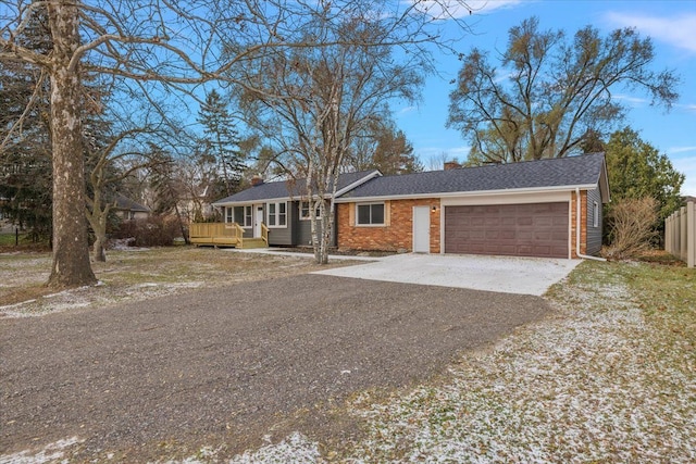 ranch-style house featuring a garage and a wooden deck