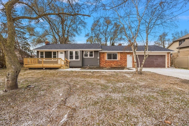 ranch-style home featuring a garage and a wooden deck