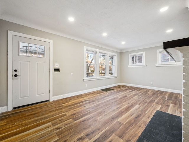 entrance foyer with hardwood / wood-style flooring, plenty of natural light, and ornamental molding