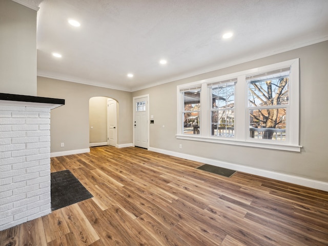 16162 Normandy St, Detroit, MI 48221 - unfurnished living room with arched walkways, crown molding, baseboards, wood finished floors, and recessed lighting