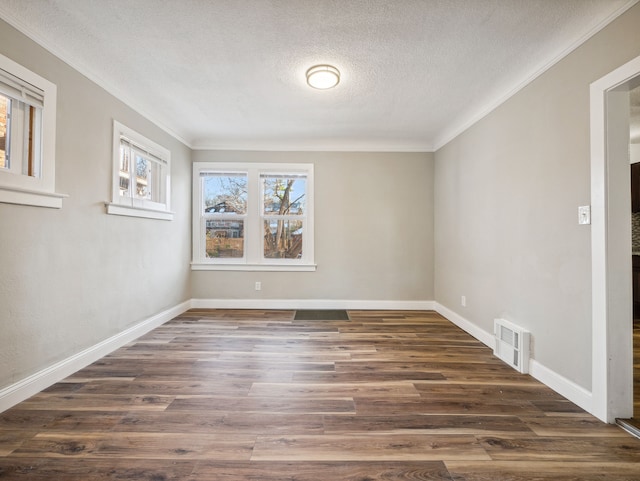 empty room featuring crown molding, dark hardwood / wood-style flooring, and a textured ceiling