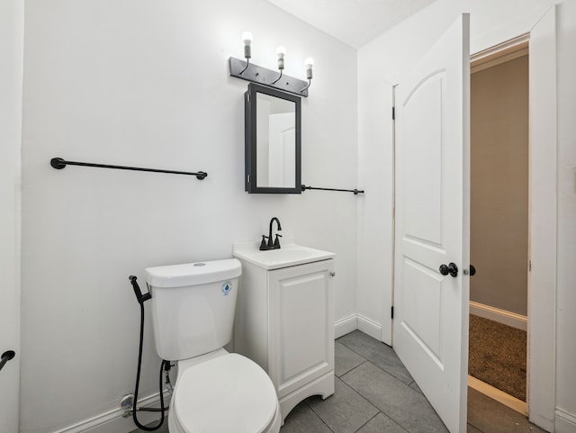 bathroom featuring tile patterned floors, vanity, and toilet