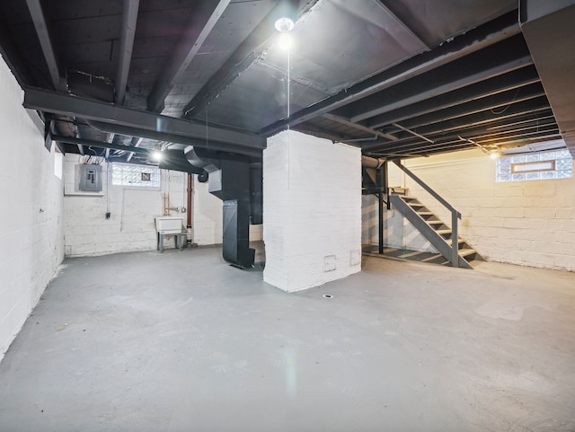 basement featuring electric panel, sink, and heating unit