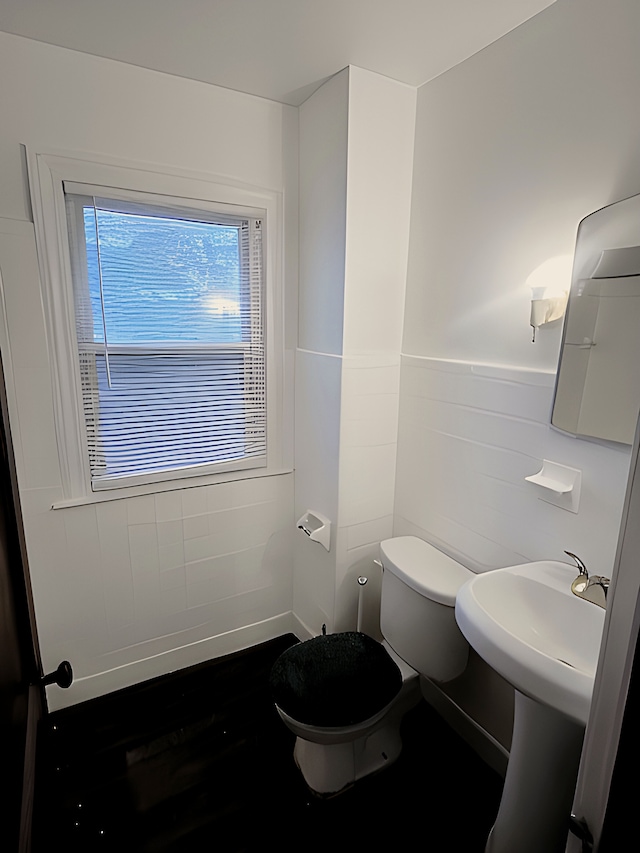 bathroom with tile walls and toilet