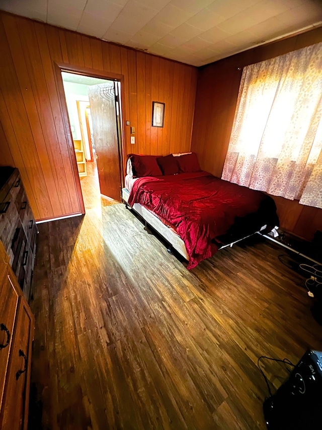 bedroom with wood walls and hardwood / wood-style floors