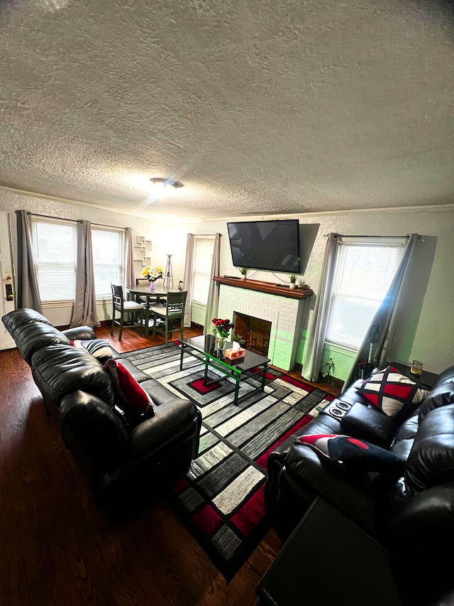 living room featuring hardwood / wood-style floors, a fireplace, plenty of natural light, and a textured ceiling