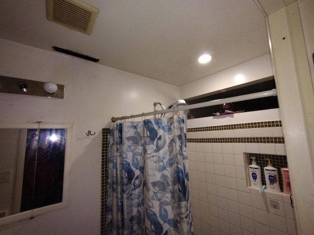 bathroom with curtained shower and tile walls