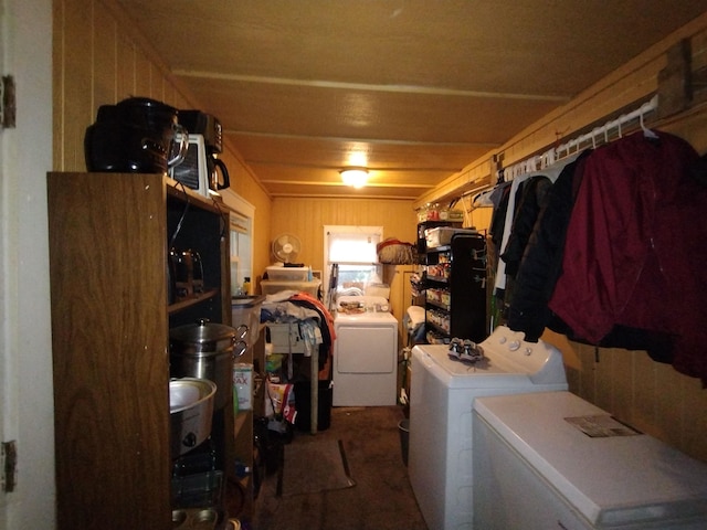 laundry room with independent washer and dryer and wood walls