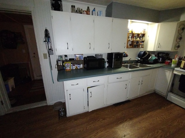 kitchen featuring dark hardwood / wood-style floors, stove, white cabinetry, and sink