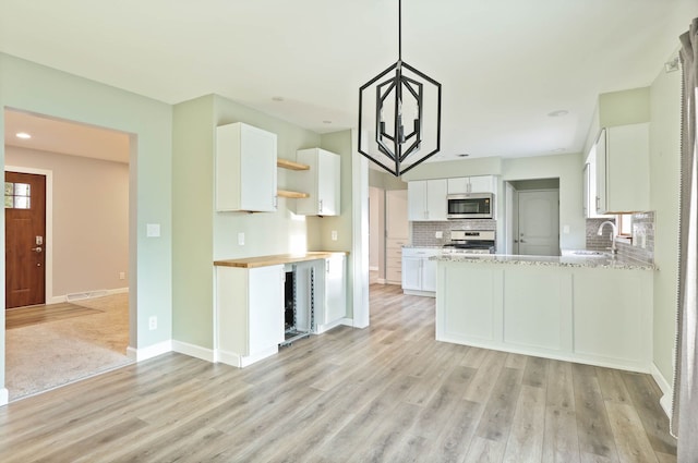 kitchen featuring appliances with stainless steel finishes, light wood-type flooring, white cabinetry, and sink