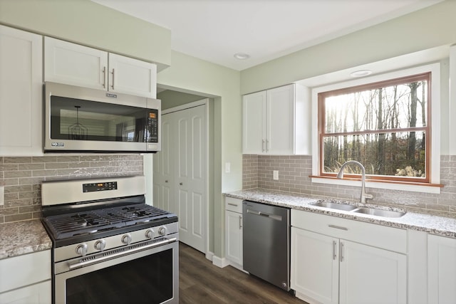 kitchen featuring backsplash, stainless steel appliances, sink, dark hardwood / wood-style floors, and white cabinetry