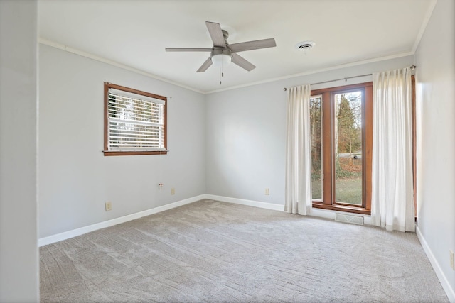 carpeted empty room with a wealth of natural light, ornamental molding, and ceiling fan