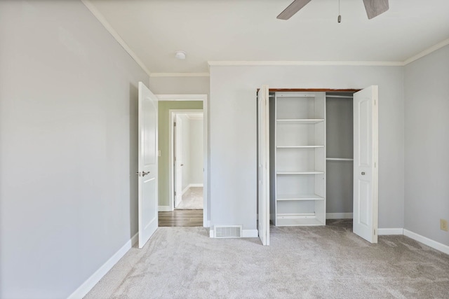 unfurnished bedroom featuring a closet, ceiling fan, crown molding, and light colored carpet