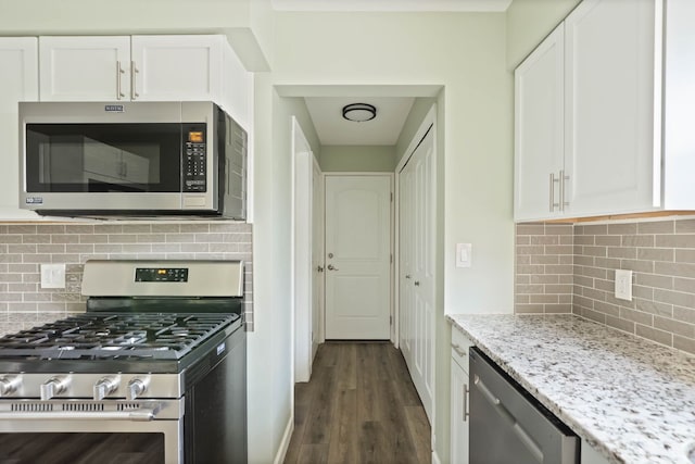 kitchen with decorative backsplash, light stone countertops, stainless steel appliances, dark wood-type flooring, and white cabinets