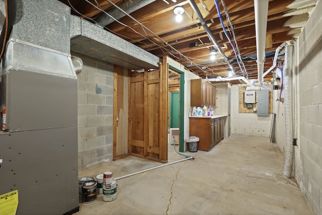 basement featuring electric panel and heating unit