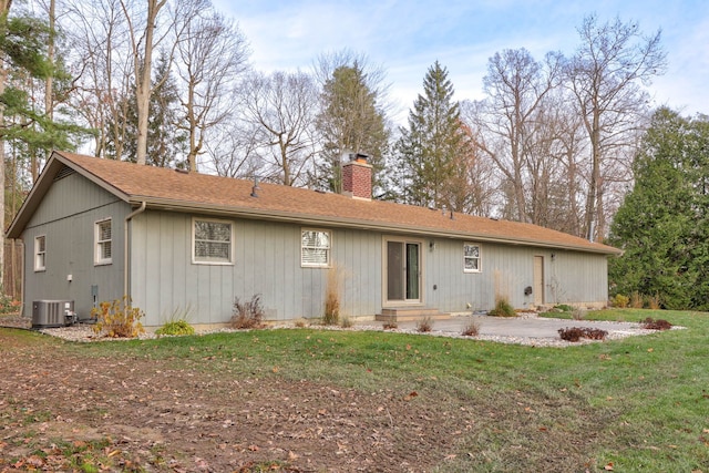 back of house with a yard and central AC unit