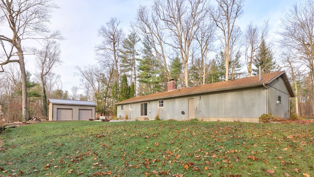 exterior space featuring a yard, an outbuilding, and a garage