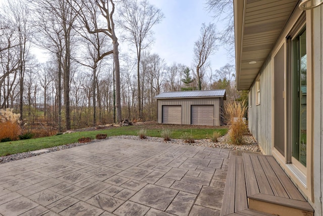 view of patio / terrace with a garage and an outbuilding