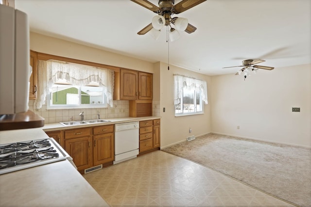 kitchen featuring tasteful backsplash, sink, white appliances, and a healthy amount of sunlight