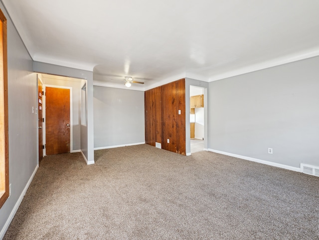 carpeted spare room with ceiling fan