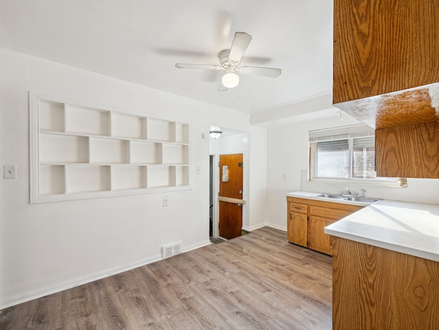 kitchen with ceiling fan, sink, and light hardwood / wood-style flooring