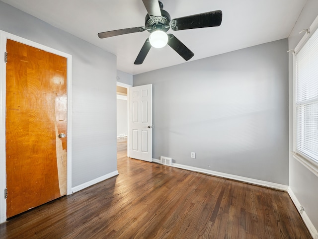 unfurnished bedroom featuring ceiling fan and dark hardwood / wood-style flooring