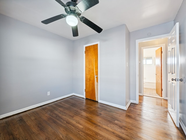 unfurnished bedroom featuring ceiling fan and dark hardwood / wood-style floors